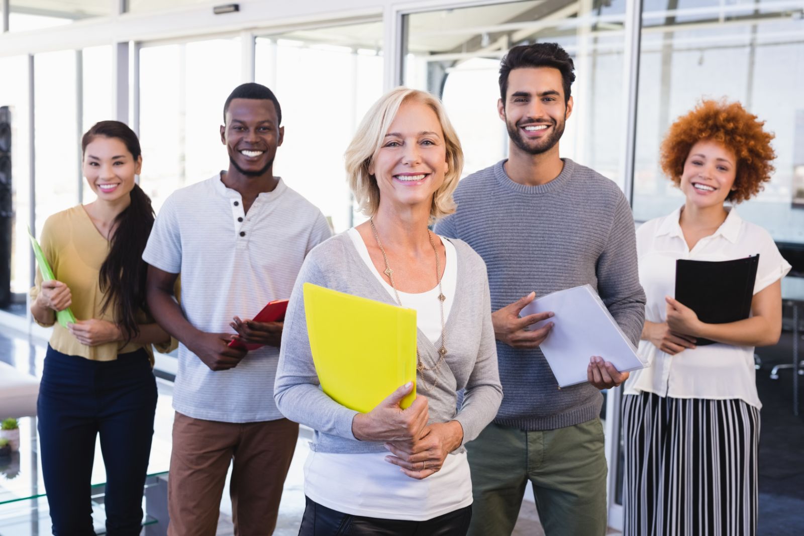 Group of smiling coworkers standing together in an office