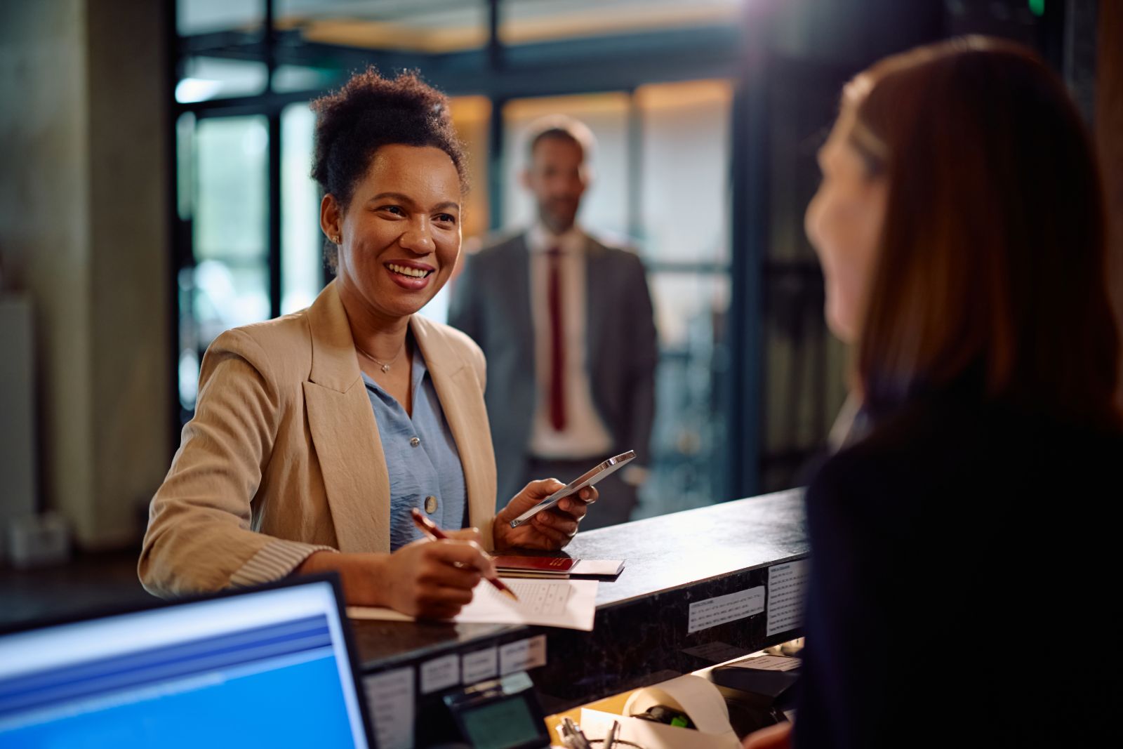 Smiling staff member helping someone at a service desk